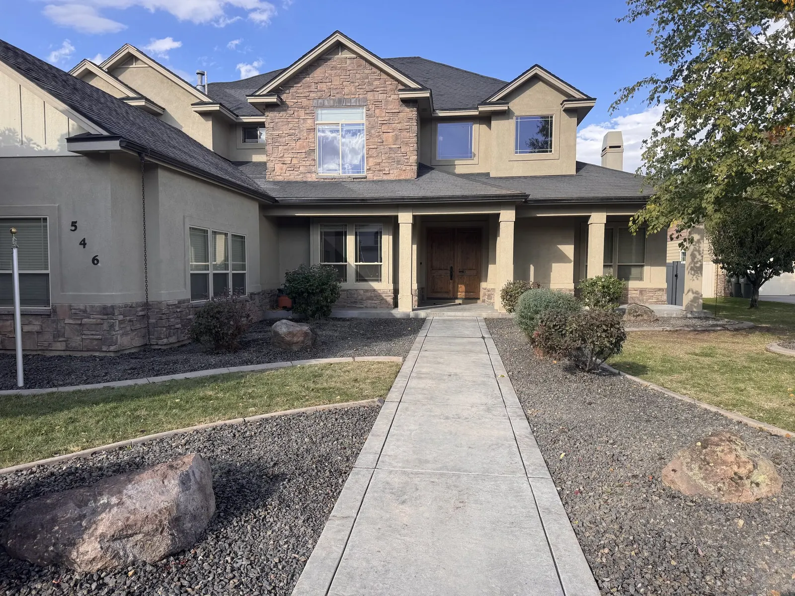 Front yard after Cato Industries build: stamped concrete walkway, clean rock-mulch beds, trimmed landscaping